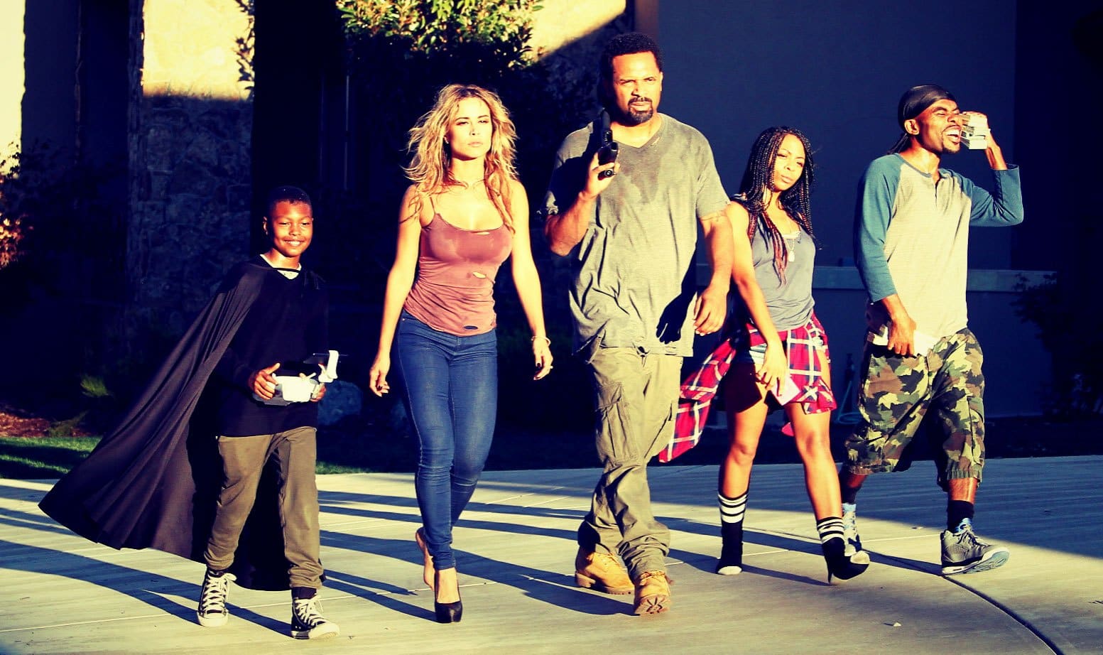 A family walking down a sunlit street in a still from Meet the Blacks (2016)